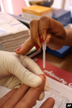 Blood is taken from Marais' finger in order to be tested for the presence of HIV