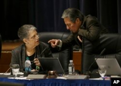 University of California President Janet Napolitano, left, talks with regent Hadi Makarechian at a Board of Regents meeting.