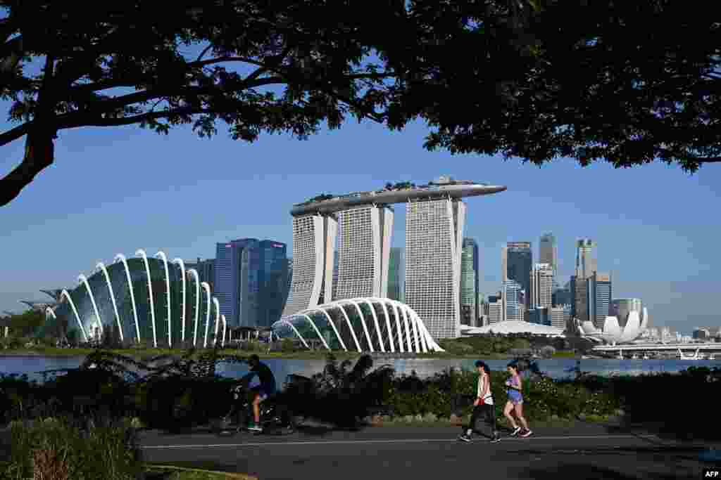 People make their way along the park at Marina Bay East as they enjoy the holiday to mark the country&#39;s National Day holiday in Singapore.