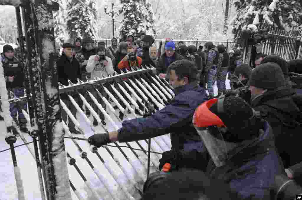 Members of the opposition party Svoboda break down a fence in front of parliament, Kyiv, Ukraine, December 12, 2012.