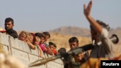 13일 이라크 북부 신자르 산 난민들이 쿠르드족 군대의 호위를 받으며 시리아 난민촌으로 떠나고 있다.