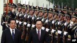 South Korean President Lee Myung-bak (2nd L) walks with Chinese President Hu Jintao (L) as they inspect a guard of honor during an official welcoming ceremony in the Great Hall of the People in Beijing January 9, 2012.