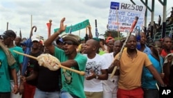 FILE - Mine workers sing and dance outside the Lonmin's platinum mine in Marikana near Rustenburg, South Africa, Thursday, Jan. 30, 2014. 