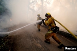 A firefighter knocks down hotspots to slow the spread of the River Fire (Mendocino Complex) in Lakeport, California, U.S. July 31, 2018. REUTERS/Fred Greaves