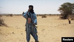 A fighter with the Tuareg separatist group MNLA stands guard outside the local regional assembly in Kidal, Mali, June 23, 2013. 