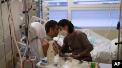 지난 23일 프랑스 남부 의료시설에서 신종 코로나바이러스 감염증 회복 환자(왼쪽)와 아내가 이마를 맞대고 있다. 