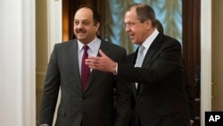 Russian Foreign Minister Sergey Lavrov, right, greets Qatari Foreign Minister Khalid bin Mohammad al-Attiyah as they enter a hall for their talks in Moscow, Russia, Friday, Dec. 25, 2015. 