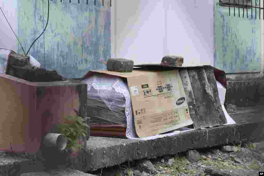 Un ataúd con el cuerpo de una persona que se supone que murió por la COVID-19 está envuelto en plástico y cubierto con cartón, afuera de un bloque de apartamentos familiares en Guayaquil.