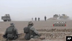 This frame grab from video provided Wednesday, Nov 8, 2017 by the government-controlled Syrian Central Military Media, shows Syrian pro-government troops taking up positions during fighting with insurgents on the Iraq-Syria border. The Britain-based Syrian Observatory for Human Rights, said that Islamic State militants have withdrawn from their last stronghold following a government offensive and that government forces and allied troops, including Iraqi fighters are combing Boukamal, a strategic town on the border with Iraq, Thursday.