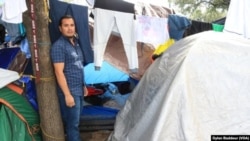 José Herman Sánchez frente a la carpa donde se refugia junto a su esposa y una pareja de Guatemala. Foto Dylan Baddour/VOA.