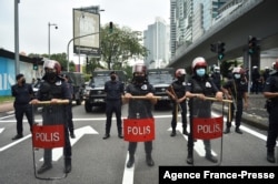 Light Strike Force team from the Royal Malaysian Police (LSF) stand at attention during a rally of 'Arrest Azam Baki' in Kuala Lumpur on Jan. 22, 2022.