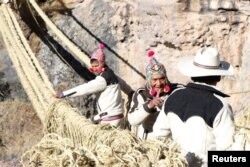 Members of the Huinchiri community rebuild an Incan hanging bridge, known as the Qeswachaka bridge, using traditional weaving techniques in Canas, Peru, June 13, 2021.