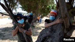 People take part in a campaign by Israel's Nature and Parks Authority calling on Israelis to join sightseeing tours and find comfort in tree hugging amid a spike in the coronavirus disease in Apollonia National Park, near Herzliya, Israel July 7, 2020. (R