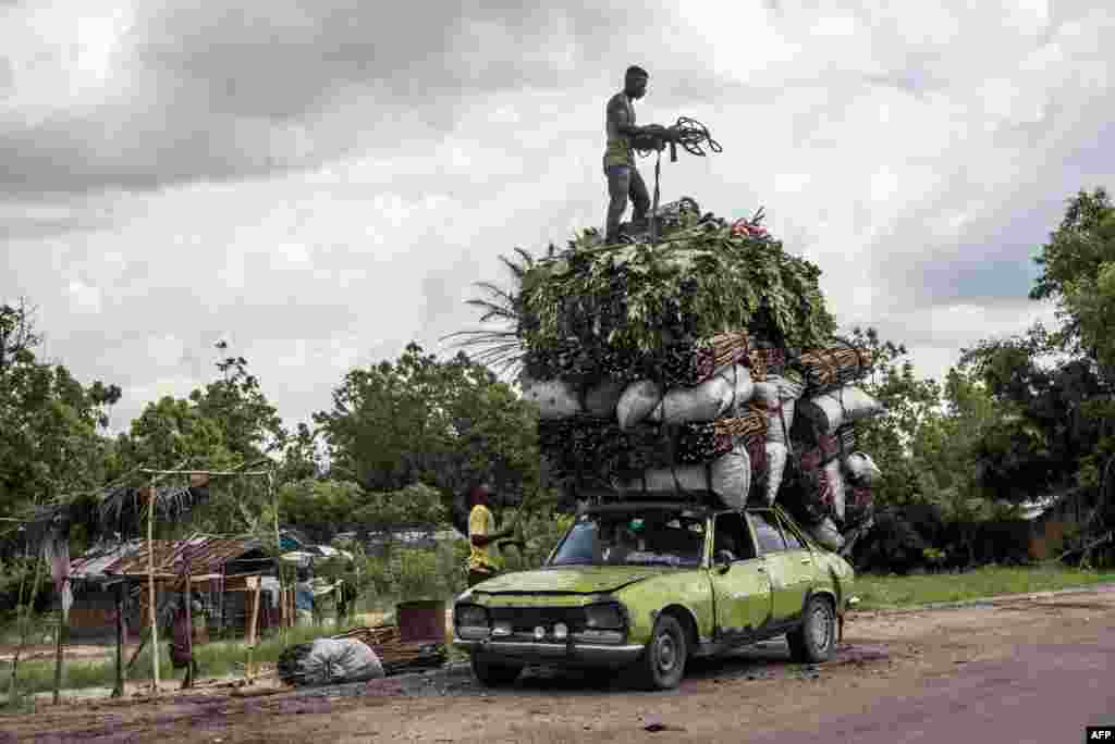 Vegetables, wood and charcoal are loaded onto the roof of a battered Peugeot, Nov. 7, 2018 in Matadi, Democratic Republic of the Congo.