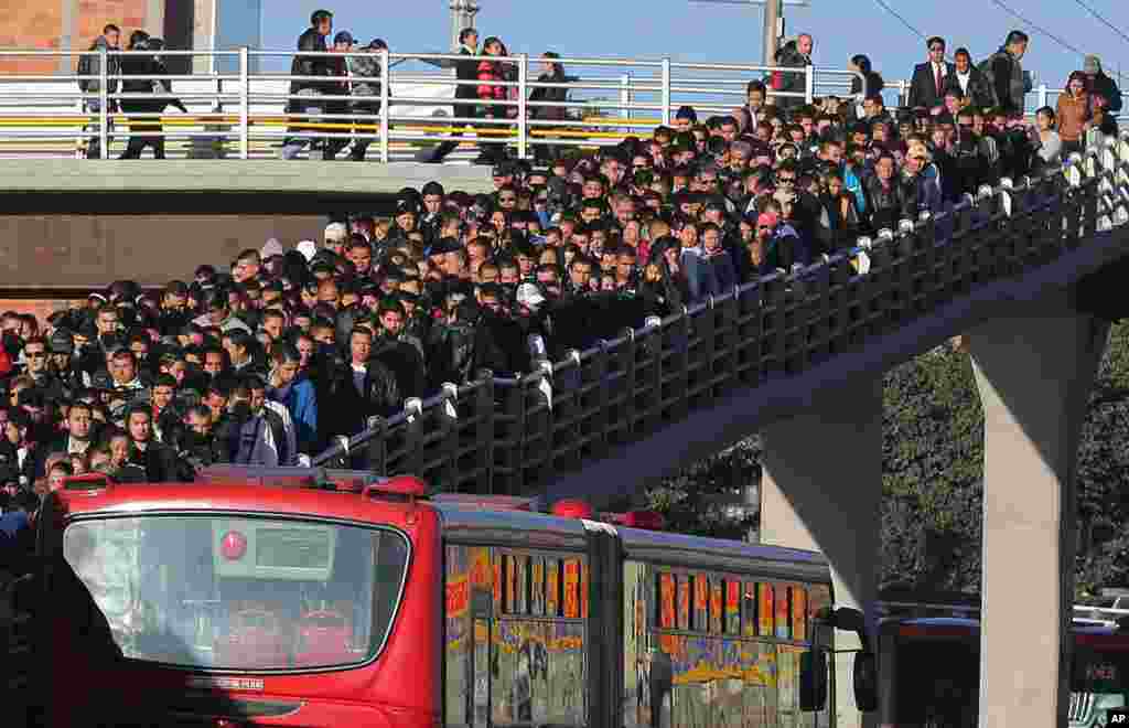 Para komuter memenuhi jembatan ketika mereka mengantri untuk menaiki bis umum pada &quot;Hari Bebas Mobil dan Motor&quot; di Bogota, Colombia. Banyak penduduk di ibukota tersebut jalan, bersepeda atau naik transportasi umum untuk mencapai tujuan mereka untuk mendukung transportasi alternatif sebagai cara mengurangi kabut asap.