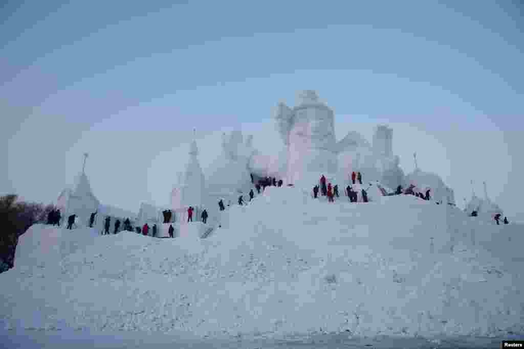 آماده سازی صحنه برای مسابقه مجسمه سازی با برف در شهر هاربین چین.