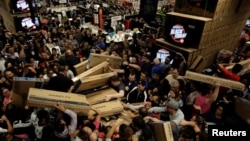 Shoppers reach out for television sets as they compete to purchase retail items on Black Friday at a...