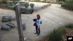 FILE - A tourist reads names on a memorial at Port Arthur, Tasmania state, Australia.