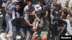 Free Syrian Army fighters and civilians help a wounded boy rescued from under rubble after what activists said was shelling by forces loyal to Syria's President Bashar al-Assad in Aleppo's Bustan al-Qasr district, Aug. 16, 2013.