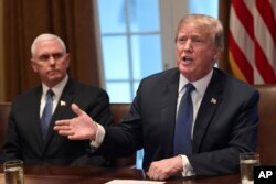 President Donald Trump, right, sitting next to Vice President Mike Pence, left, speaks in the Cabinet Room of the White House in Washington, April 9, 2018, at the start of a meeting with military leaders.