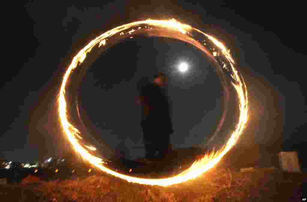 A resident twirls a can with holes filled with burning wood chips and straws to celebrate the first full moon of the Lunar New Year, in Yongin, South Korea. 