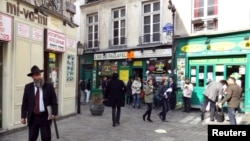FILE - People walk in the street in the Marais Jewish quarter in Paris.