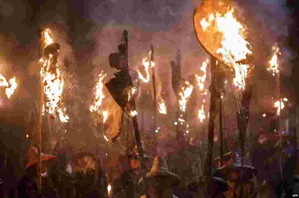 &#39;Mayorganos&#39; (Mayorga locals) carry flaming wineskin torches during the &#39;Vitor&#39;s Civic Procession&#39; in Mayorga, near Valladolid, Spain, Sept. 27, 2017.