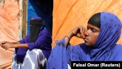 Faadumo Ali Fiidow duduk bersama putrinya Hafsa Ali Osman, 15, yang diduga dipaksa menikah, di tempat penampungan sementara di kamp Alafuuto, Mogadishu, Somalia, 14 Agustus 2020 (Foto: Reuters)