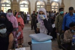 A health worker prepares to inoculate a man with a dose of the Sinopharm Covid-19 coronavirus at a vaccination centre in Karachi on May 26, 2021.
