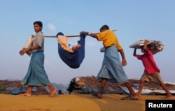 Rohingya refugees carry their sick relative to a medical center at Kutupalong refugee camp near Cox's Bazar, Bangladesh Oct. 24, 2017.