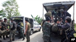 Members of the Philippine National Police Special Action Forces load bodies of police commandos into vehicles in Maguindanao, Philippines, Jan. 26, 2015.