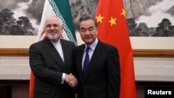 چین ایران اجلاس کے بعد، ایرانی وزیر خارجہ جواد ظریف اپنے چینی ہم منصب، وینگ یی کے ساتھ ہاتھ ملاتے ہوئے۔ (فائل)