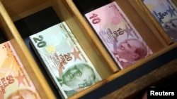 Uang kertas Turki Lira di tempat penukaran mata uang asing di Istanbul, Turki, 13 Agustus 2018. 