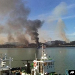 Picture taken by a South Korean tourist shows huge plumes of smoke rising from Yeonpyeong island in the disputed waters of the Yellow Sea on 23 Nov 2010