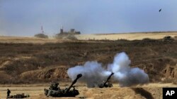 An Israeli tank fires towards Gaza, near the Israel and Gaza border, July 27, 2014.