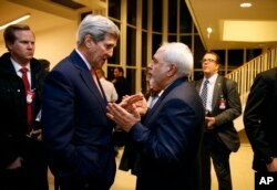 FILE - In this Jan. 16, 2016, photo, Secretary of State John Kerry talks with Iranian Foreign Minister Mohammad Javad Zarif in Vienna, after the International Atomic Energy Agency verified that Iran has met all conditions under the nuclear deal.