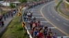 FILE - Central American migrants, part of a caravan hoping to reach the U.S. border, walk in Frontera Hidalgo, Mexico, April 12, 2019.