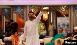 FILE - Aamir Liaquat Hussain gestures during a live show in Karachi, Pakistan, July 26, 2013.