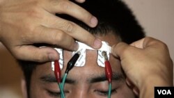 တရုတ်နိုင်ငံ အလုပ်သမားစခန်းမှာ မူးယစ်ဆေးစွဲသူရဲ့ အရေပြားအပူချိန်ကို တိုင်းဖို့ လျှပ်စစ်စီးအားသုံး တိုင်းတာစက်ဖြင့် စစ်ဆေးနေပုံ။