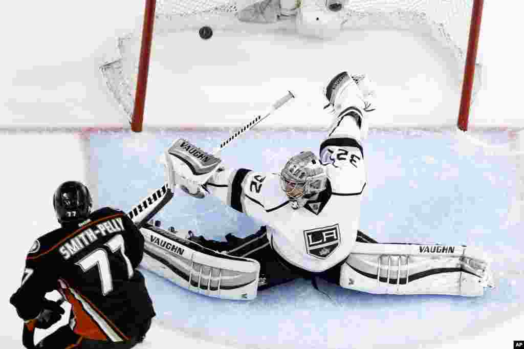 Pemain hoki es klub Anaheim Ducks, Devante Smith-Pelly (kiri) mencetak gol ke gawang Los Angeles Kings yang dijaga kiper Jonathan Quick di Anaheim, California, AS.