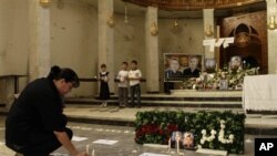 A woman lights a candle for the siege victims at Our Lady of Salvation church in Baghdad, Iraq.