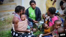 Displaced people get food and drink after arriving at the airport of the coastal city of Beira in central Mozambique on March 19, 2019, which was hit by Cyclone Idai.