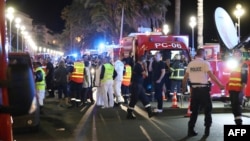 Police officers, firefighters and rescue workers are seen at the site of an attack on July 15, 2016, after a truck drove into a crowd watching a fireworks display in the French Riviera town of Nice.