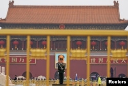 A paramilitary policeman stands guard before a giant portrait of late Chinese Chairman Mao Zedong at the Tiananmen gate, a day before the 19th National Congress of the Communist Party of China begins, in Beijing, China, October 17, 2017.