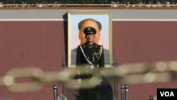 တီအန်နန်မဲန်ရင်ပြင်အတွင်း တရုတ်နိုင်ငံရဲ့ခေါင်းဆောင်ဟောင်း မော်စီတုန်းရဲ့ ဓာတ်ပုံရှေ့က လုံခြုံရေးအစောင့်တာဝန်ကျ စစ်သည်တစ်ဦး။