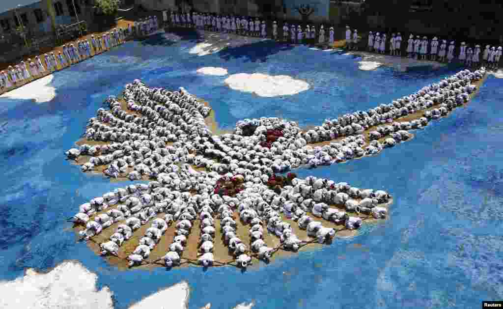 Students arrange themselves into the formation of a dove to commemorate the 68th anniversary of the atomic bombings of Japanese cities Hiroshima and Nagasaki, in the southern Indian city of Chennai. 