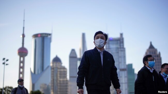 戴着口罩的行人行走在上海陆家嘴金融区的街道上。(2020年3月19日)