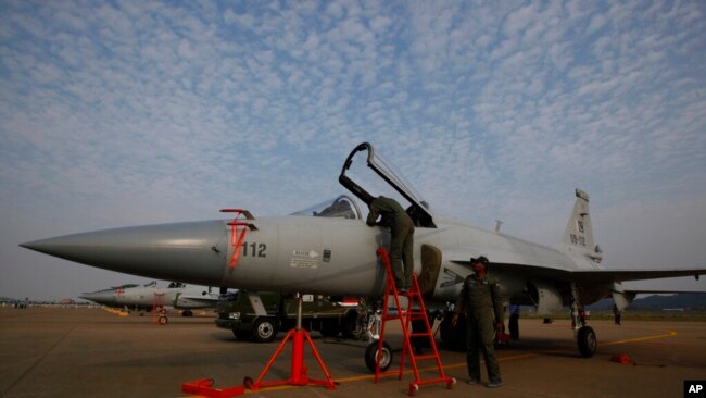 FILE - Pakistan Air Force personnel check an FC-1 Xiaolong multirole fighter at the 8th China International Aviation and Aerospace Exhibition in Zhuhai, southern China, Nov. 15, 2010.