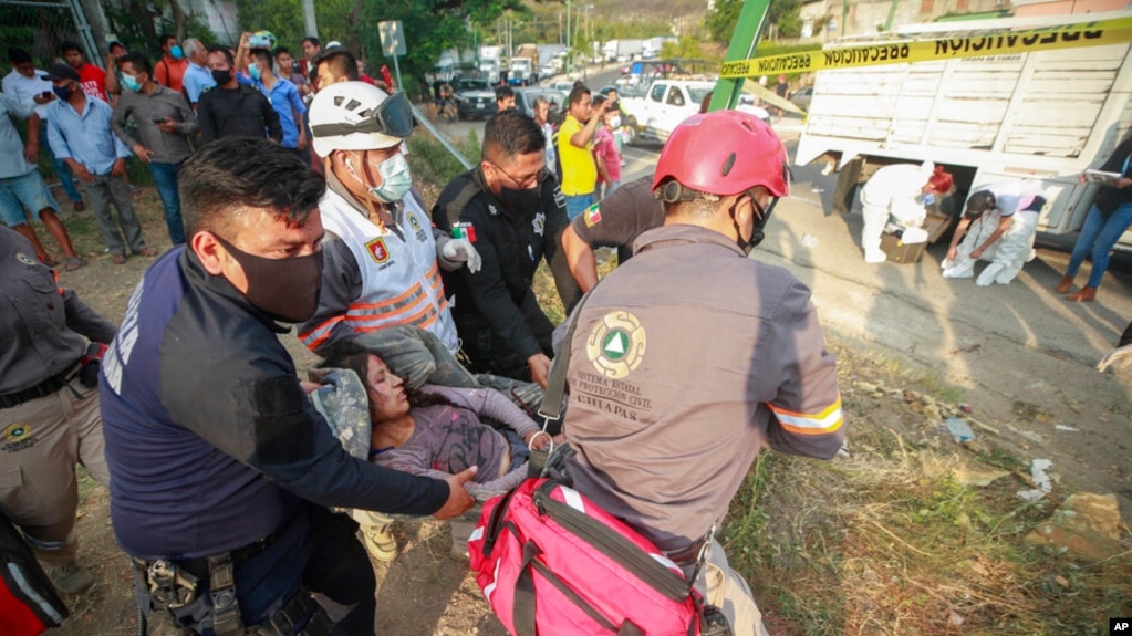 An injured migrant woman is moved by rescue personnel from the site of an accident near Tuxtla Gutierrez, Chiapas state, Mexico, Dec. 9, 2021. migrants rolled over on the highway in southern Mexico. (AP Photo)