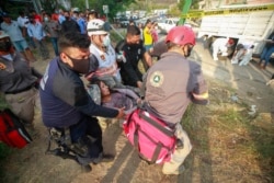 An injured migrant woman is moved by rescue personnel from the site of an accident near Tuxtla Gutierrez, Chiapas state, Mexico, Dec. 9, 2021.